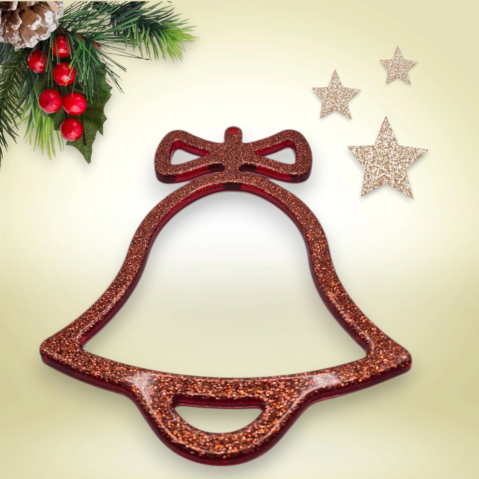 suspension de noël en forme de cloche en résine pailletée rouge posée sur un fond décoratif avec branche de sapin et étoiles scintillantes