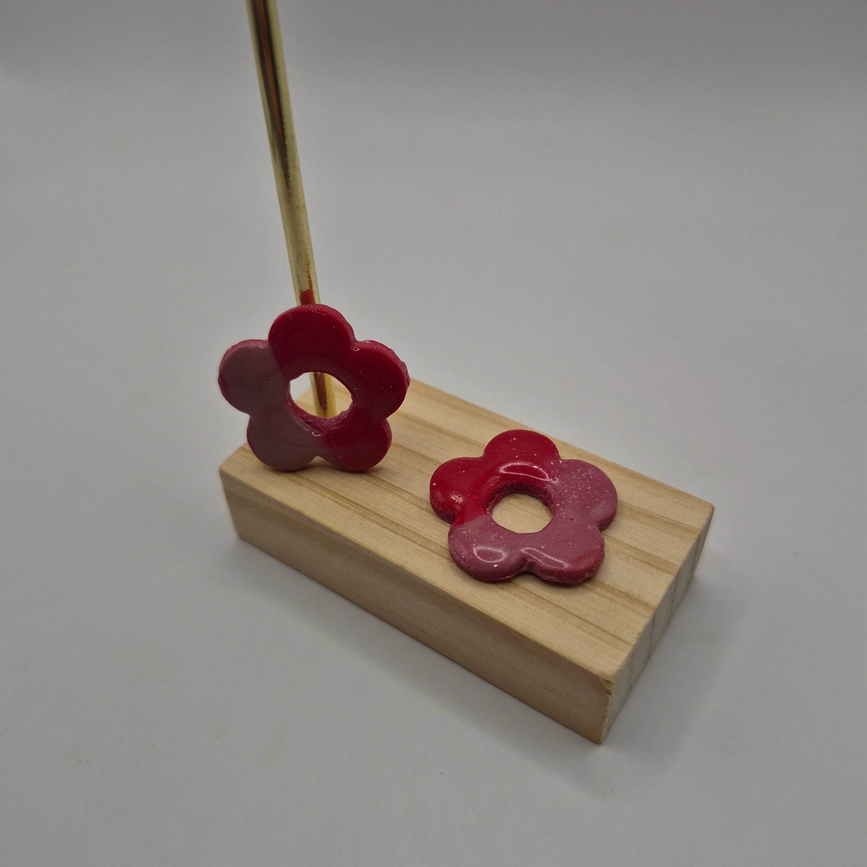 Pampilles fleur rose en pâte polymère pour boucles d’oreilles interchangeables – accessoires créatifs faits main pour bijoux artisanaux, présentés sur un support en bois.