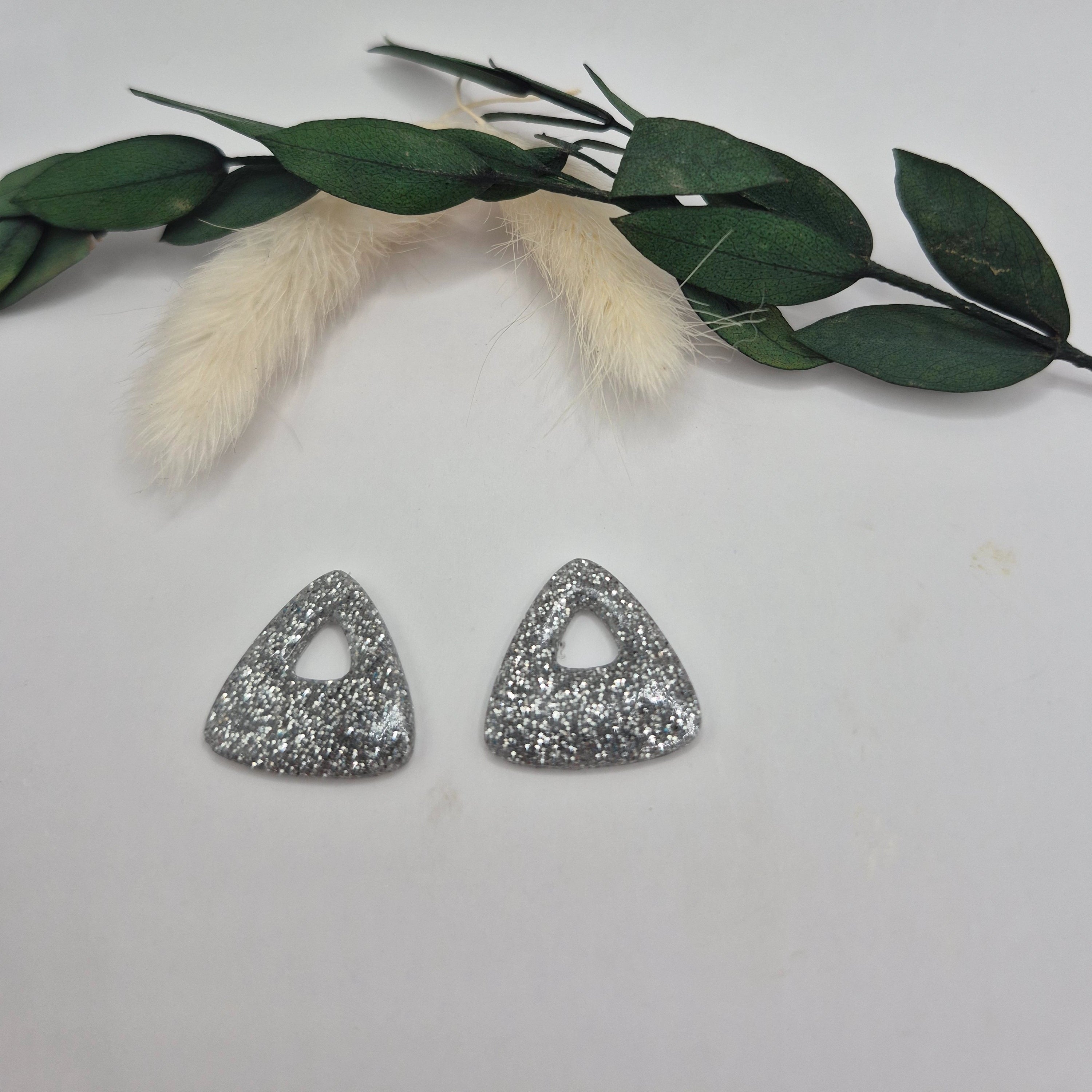 Pampilles Julie argentées résine pailleté posées à plat avec branche verte et pampa en fond de décor