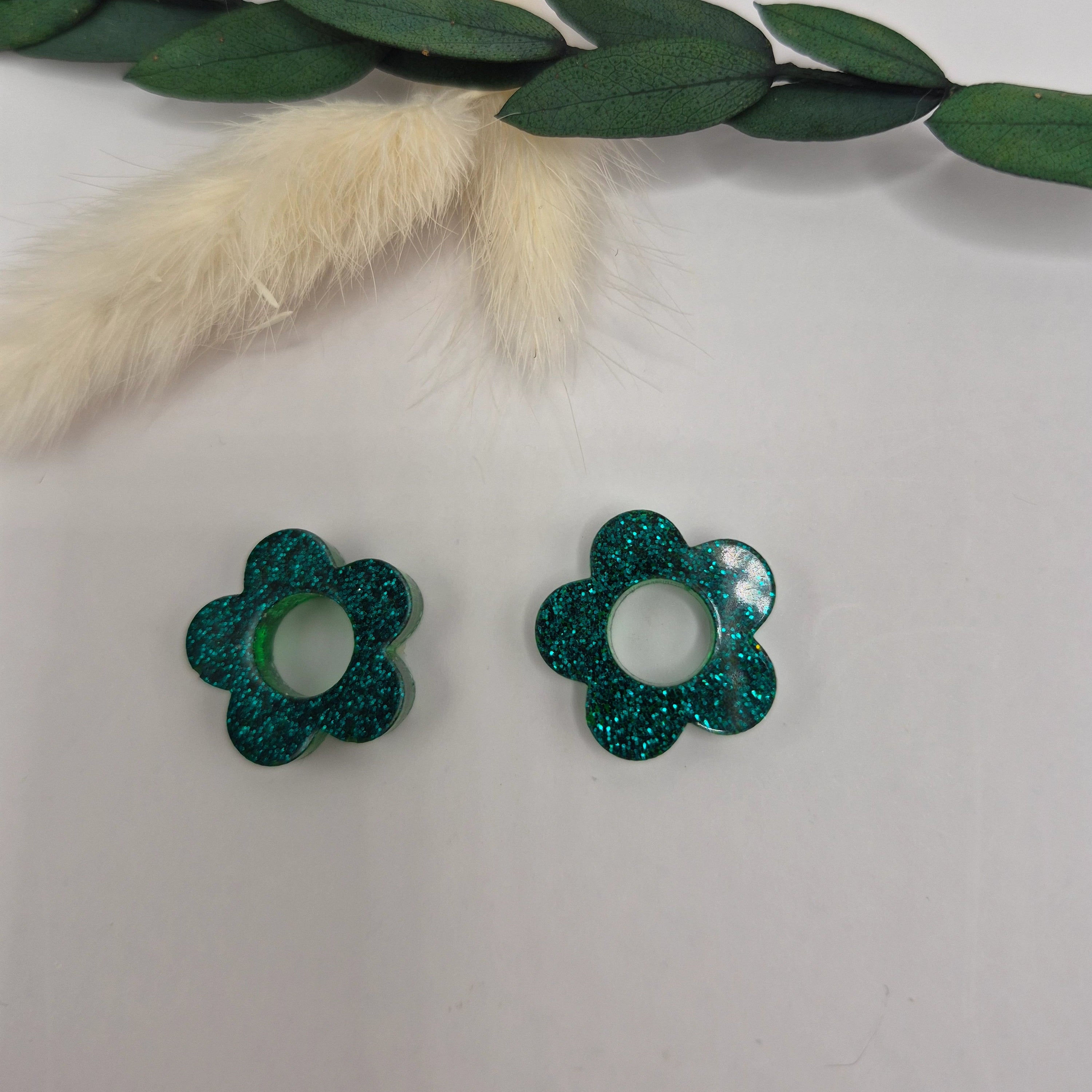 Pampilles Lexie vertes résine pailletée posées à plat verte et pampa en fond de décor