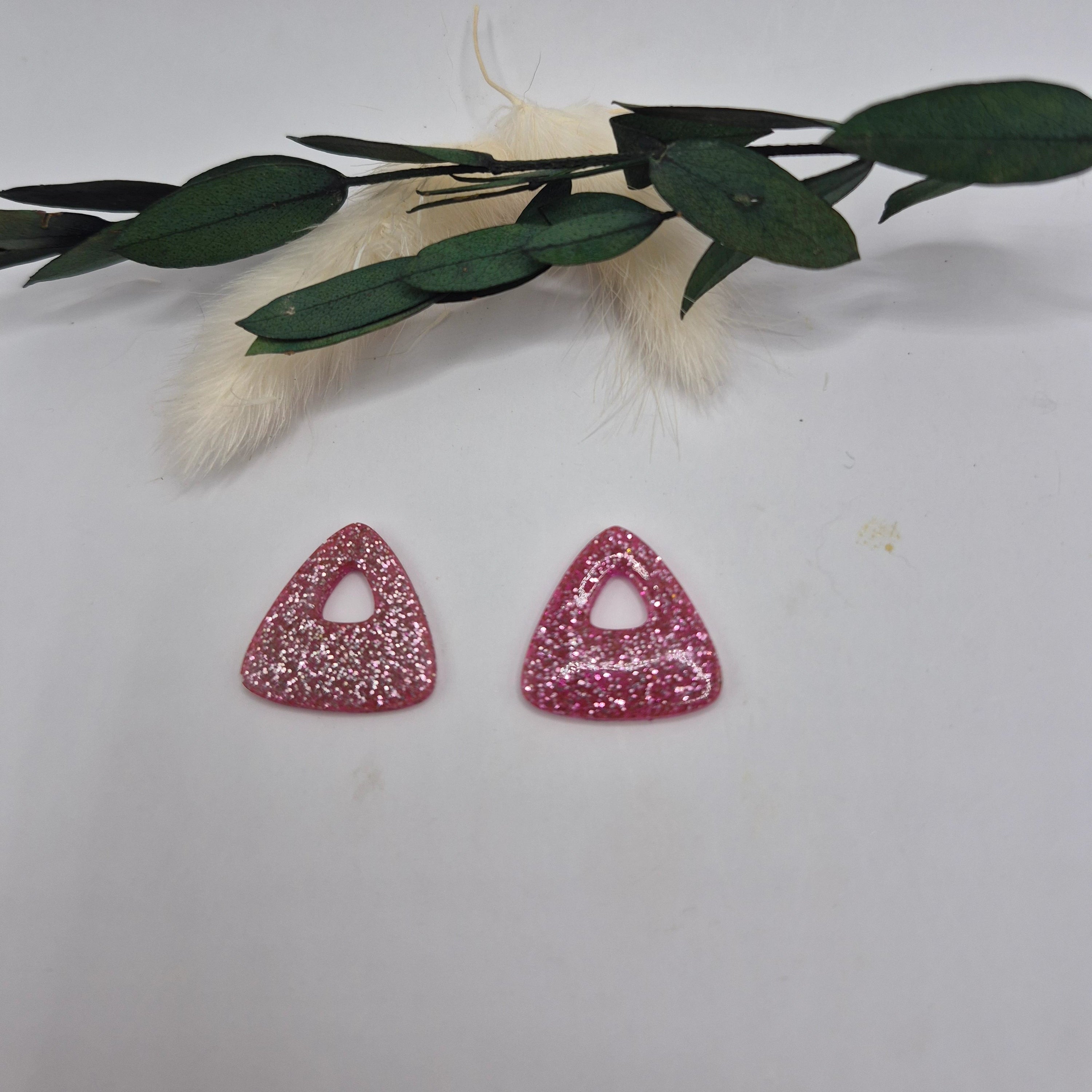 Pampilles Julie roses résine pailletée posées à plat avec branche verte et pampa en fond de décor