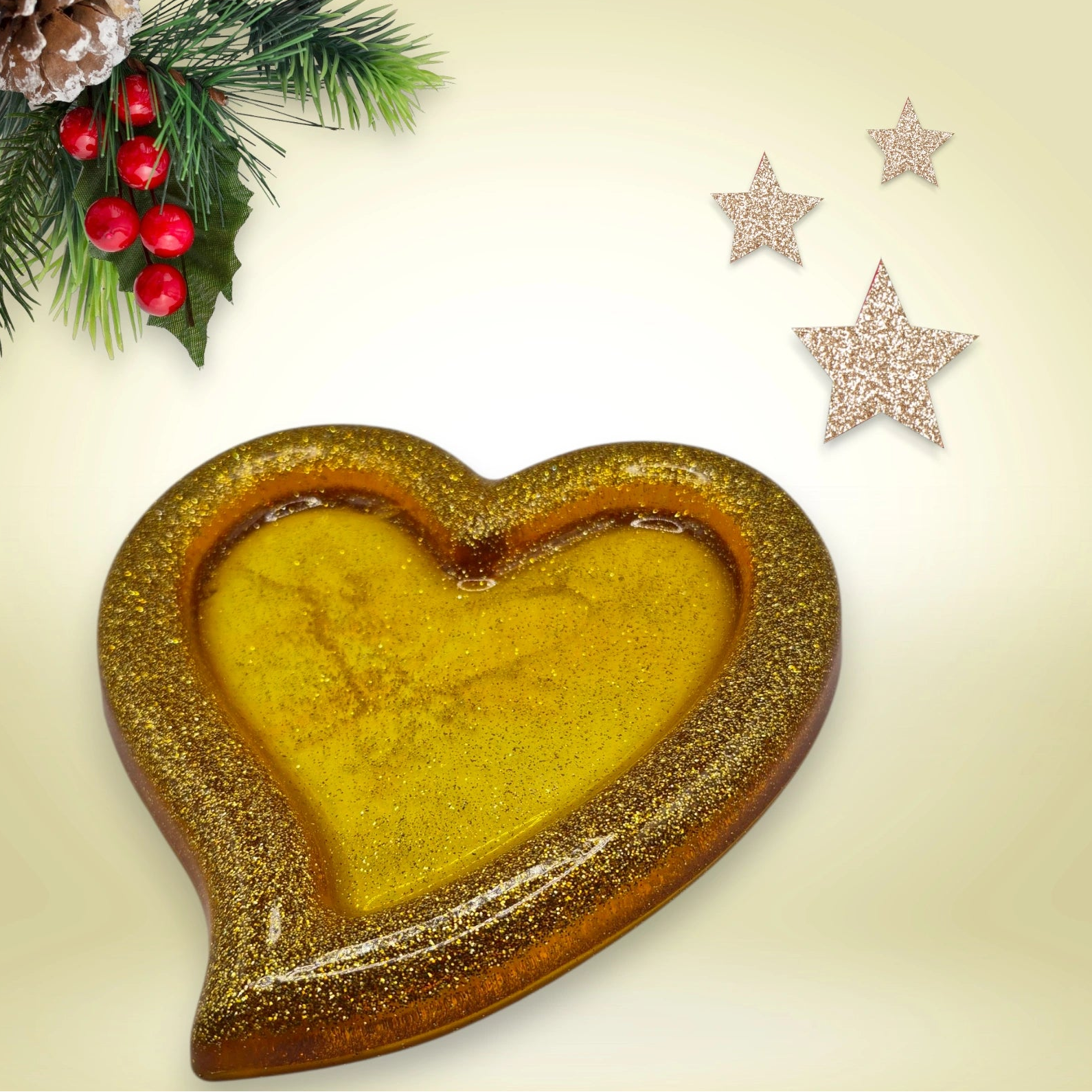 Vide-poche en forme de coeur en résine pailletée dorée présenté sur un fond décoratif.