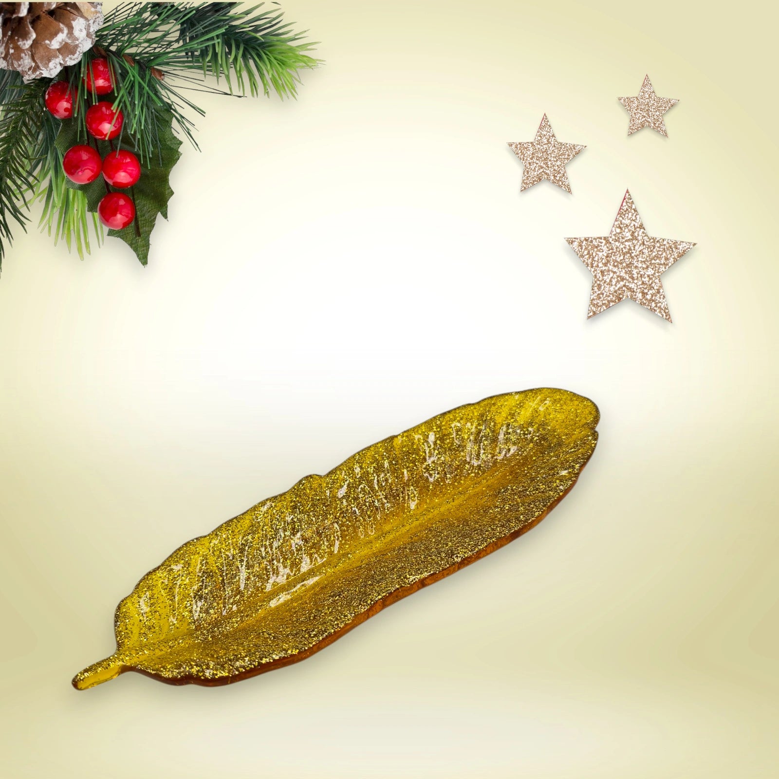 Vide-poche en forme de plume en résine pailletée dorée posée sur un fond décoratif